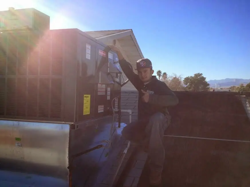 HVAC technician performing AC Tune-Up on a rooftop unit in Troutdale